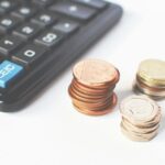 O nas Close-up of stacked coins and a calculator symbolizing financial strategy and budgeting.