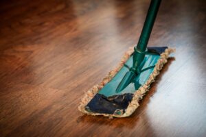 O nas A detailed view of a mop cleaning a wooden floor, showing texture and pattern.